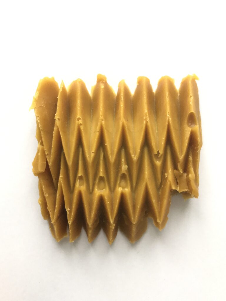 Relief géométrique en cire d’abeille obtenu par moulage dans un moule en papier plié.